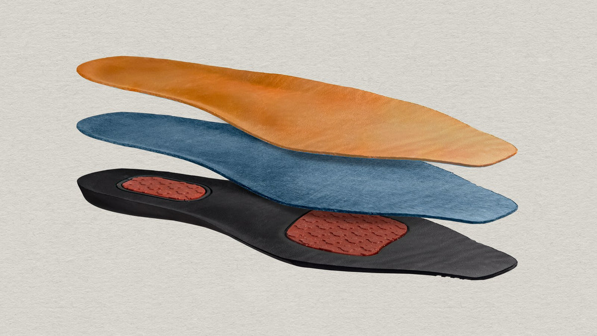 The chisos.momfort insole shown in three separated layers: leather top, cushioning layer and base with gel pads at the heel and ball