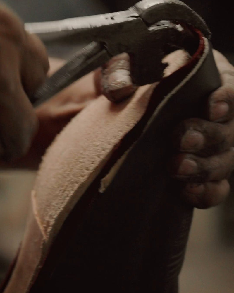 Lasting pliers pulling the leather upper over the last by hand